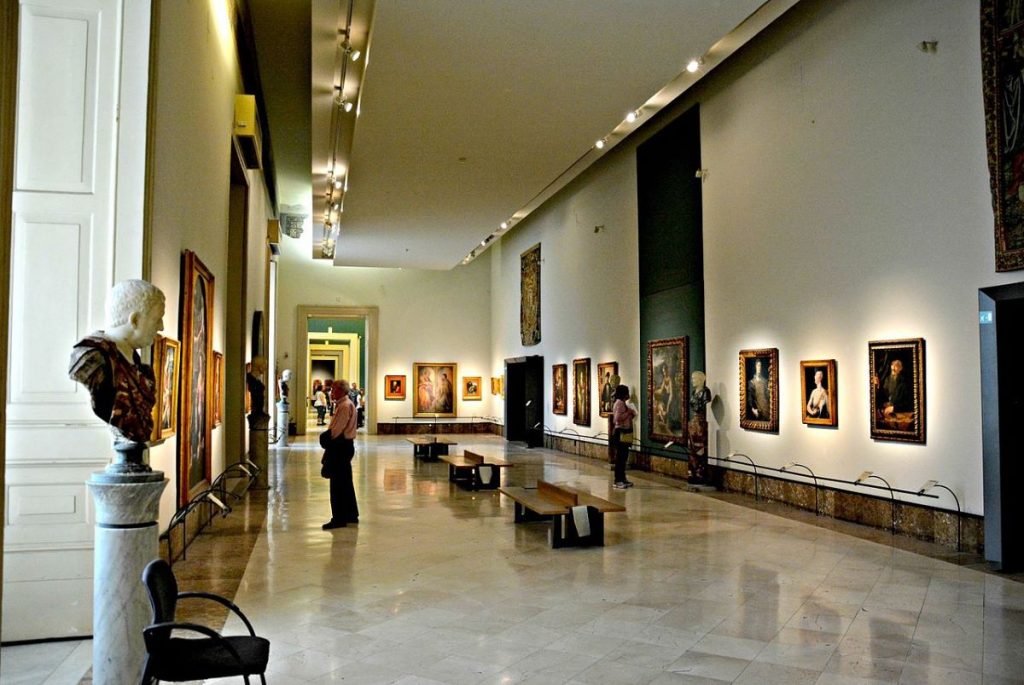 People walking around Museo Nazionale di Capodimonte looking at artwork.