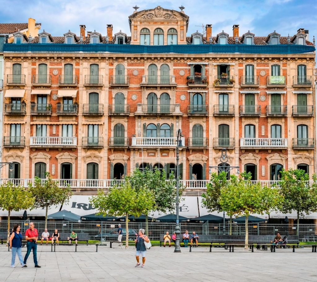 People walking in Plaza del Castillo in Pamplona. Pamplona is one of the day trips from San Sebastian people can go on. 