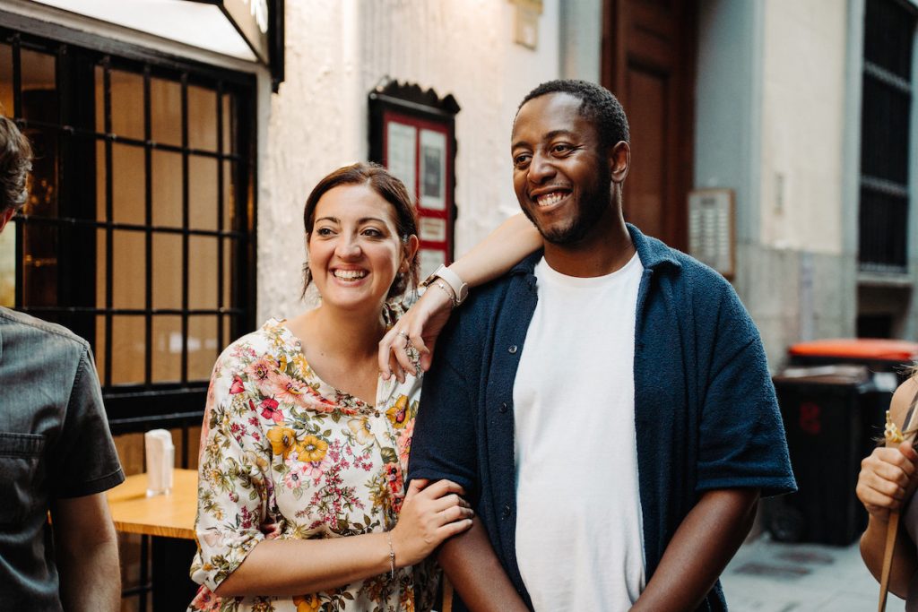 No travel guide to Seville is complete without the best tapas spots. A couple smile in the street of the spanish city of Seville