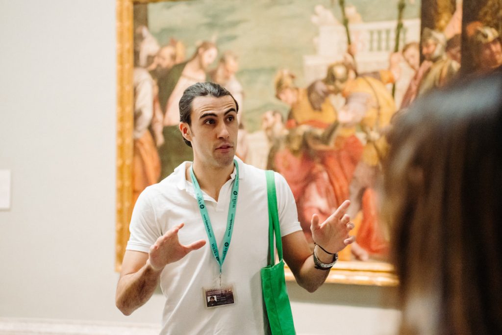 Tour guide explaining a painting at the Prado Museum