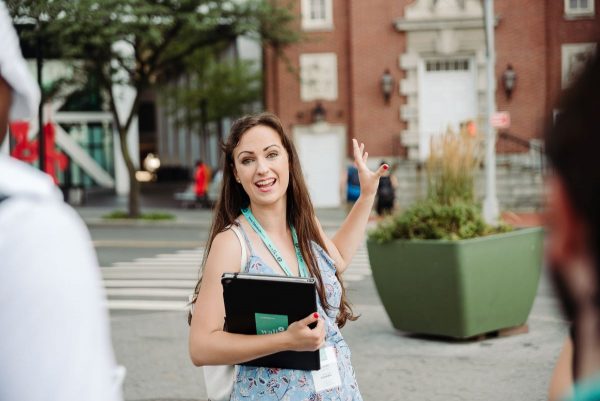 A woman standing in front of the James Watson House in New York.