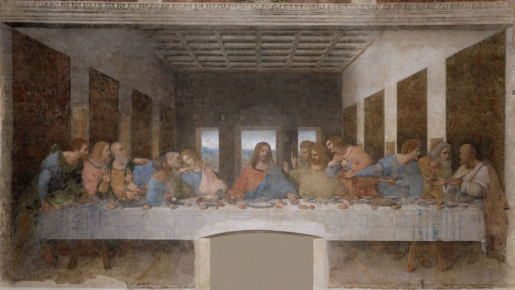 Jesus sits at the center of a long table with twelve disciples in the refectory of Santa Maria delle Grazie, Milan.